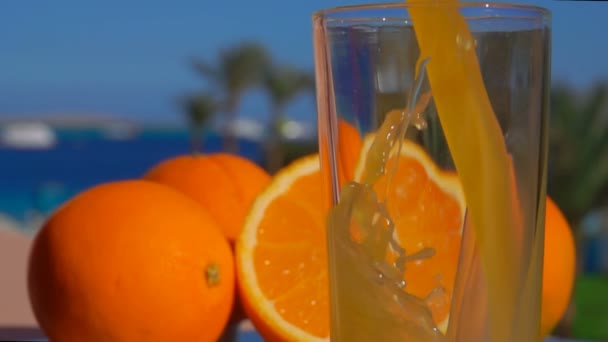 Close-up sinaasappelsap, gegoten in een glas — Stockvideo