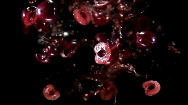 Whole and halves of cherry with juice flies to the camera — Stock Video