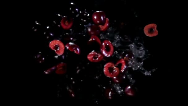 Целые половинки вишни с водой летят в камеру — стоковое видео