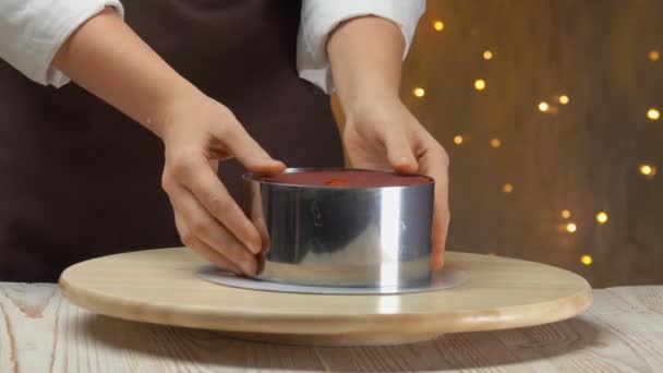 Confectioner removes a metal mold from a red velvet cake — Stock Video