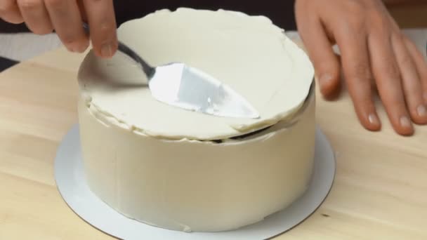 Cream on the cake leveled with a spatula — Stock Video