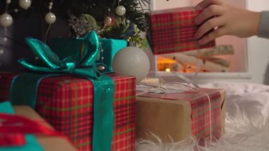 Noel ağacının altında bir hediye koyarak el