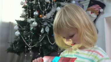 Küçük kız Noel ağacı yakınındaki bir Noel hediyesi verdi