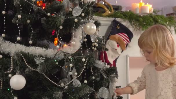 Kleines Mädchen schmückt einen Weihnachtsbaum — Stockvideo