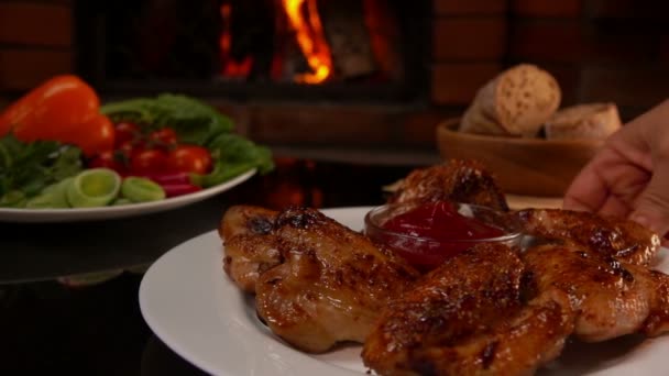 Pon a mano sobre la mesa un plato de alitas de pollo frito — Vídeo de stock