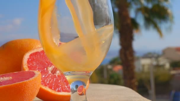 Grapefruktjuice hälls i ett vin-glas — Stockvideo