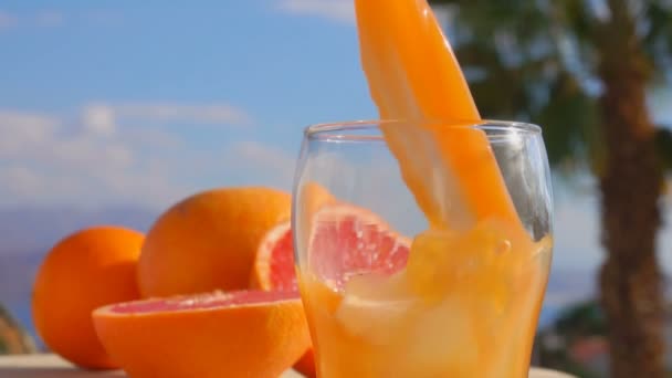 Grapefruktjuice hälls i ett glas — Stockvideo