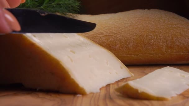 Нож отрезает кусочек мягкого овечьего сыра — стоковое видео