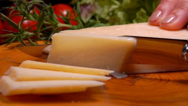 Шматок твердого сиру Пармезан нарізаний ножем на скибочки — стокове відео