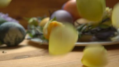 Paskalya yumurtaları bir masada bir sarı gül yaprakları düşmek