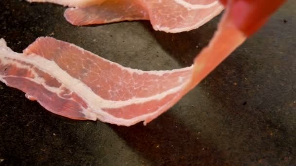 Bandes de bacon sont empilés sur un gril de pierre chaude — Video