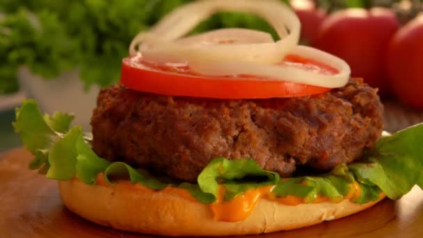 Кольца нарезанного лука падают на гамбургер — стоковое видео