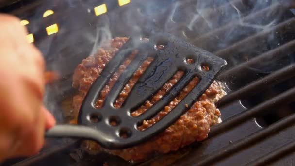 Бургер нажата кухонной лопаткой на гриль — стоковое видео