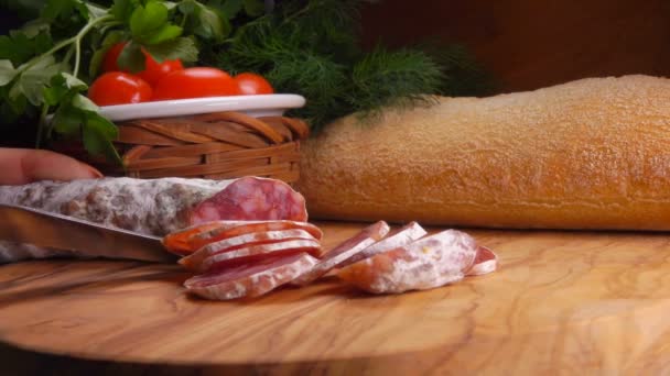 Faca corta um pedaço de salsicha picante defumada — Vídeo de Stock