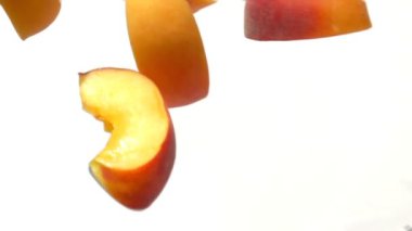 Şeftali dilimleri yakın çekim beyaz bir arka plan üzerinde uçmak.