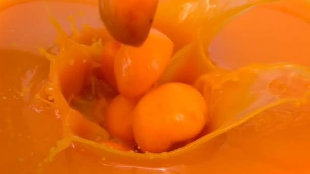 Halves ripe apricots fall into juice — Stock Video