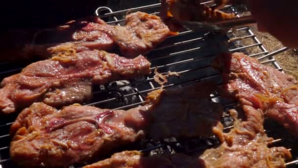 Шеф-повар делает стейк из баранины металлическими щипцами — стоковое видео