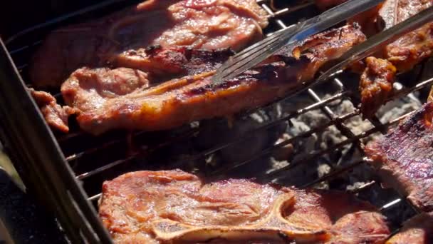 Cook lays the lamb steak with a metal tongs — Stock Video