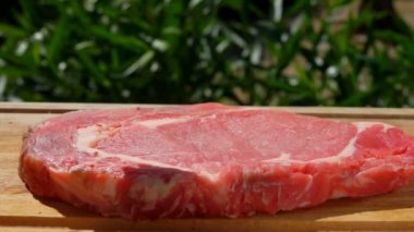 Baharat düşüyor domuz biftek ahşap oyun tahtası üzerinde
