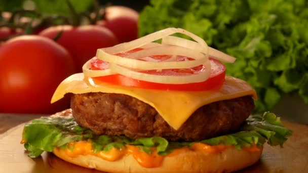 Ingemaakte komkommer plakjes vallen op een cheeseburger — Stockvideo