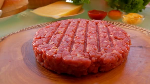 Hamburguesa de carne cruda se encuentra en una tabla de madera — Vídeo de stock