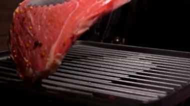 Cook biftek ızgara ızgara maşa kullanarak koyar