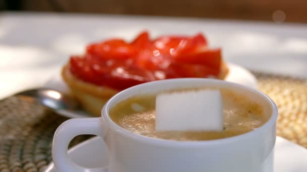 Un morceau de sucre tombe dans une tasse de café expresso — Video