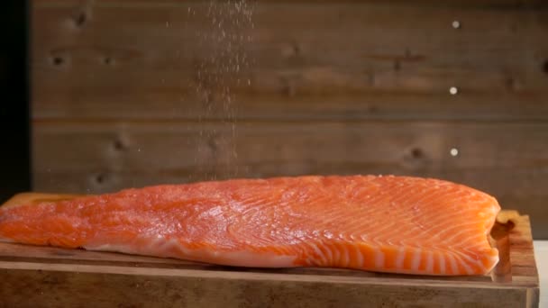 Tuz dökülen Çiğ somon fileto üzerinde — Stok video
