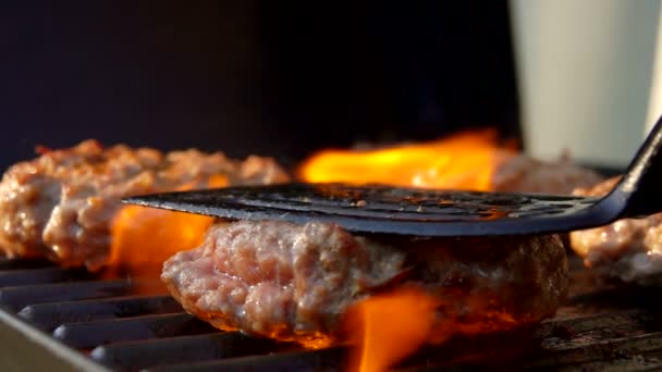 Hamburguesas es presionado por espátula de cocina a la parrilla — Vídeos de Stock