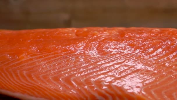 Close-up of salt strewed on raw salmon fillet — Stock Footage Close-up of salt strewed on raw salmon fillet Stock Footage