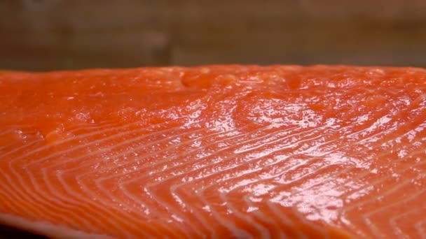 Primer plano de la sal esparcida sobre el filete de salmón crudo — Vídeos de Stock