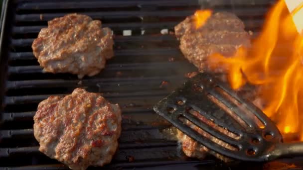 Tasty beef burgers flipping on the grill. — Stock Video