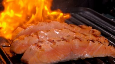 Bir açık ateş üzerinde üç adet somon fileto ızgara