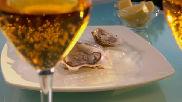 Oesters en mousserende wijn liggen op tafel. — Stockvideo