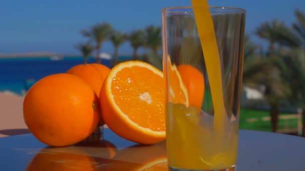 Close-up suco de laranja fresco derramado em um copo — Vídeo de Stock