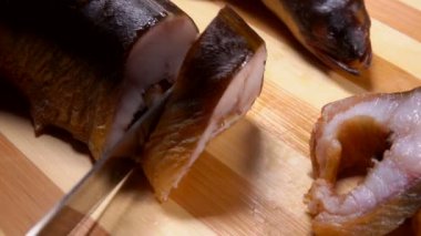 Füme yılan balığı parçaları olarak kesilir