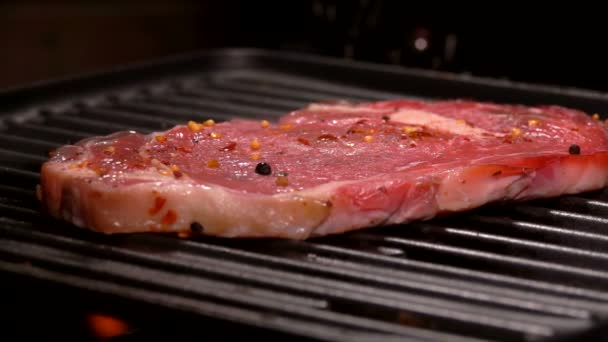 La fumée s’élève au-dessus du steak sur un gril chaud. — Video