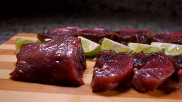 Stukjes gezouten tonijn en kalk liggen op een bord — Stockvideo