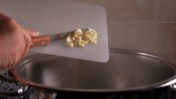 Hostess feláll apróra vágott fokhagymát a vízbe — Stock videók