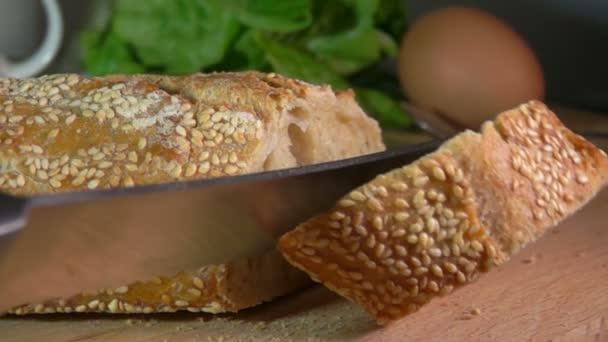 Mes snijden stokbrood met sesamzaadjes — Stockvideo