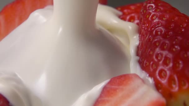 Strawberry halves fall into milk — Stock Video