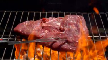 Cook biftek ızgara üzerinde açık bir yangın bırakır