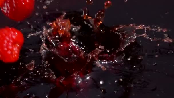 Framboises rouges mûres tombent dans le jus — Video