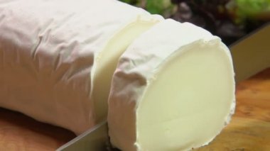 Keçi peyniri ile gri küf parçasını bir bıçak ile kesmek