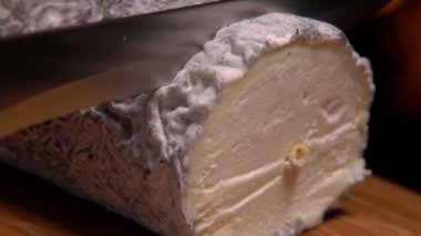 Gri kalıplı peynir bir tahta üzerinde bıçak kesilir