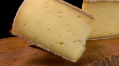 Bir ahşap tahta üzerine düşen peynir dilimleri