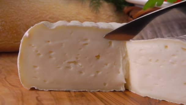 Faca corta uma fatia de queijo francês redondo — Vídeo de Stock
