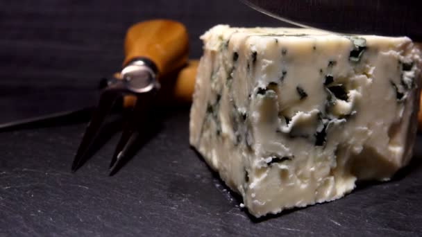 Bıçak keser ve mavi kalıp peynir bir parça kaldırır — Stok video