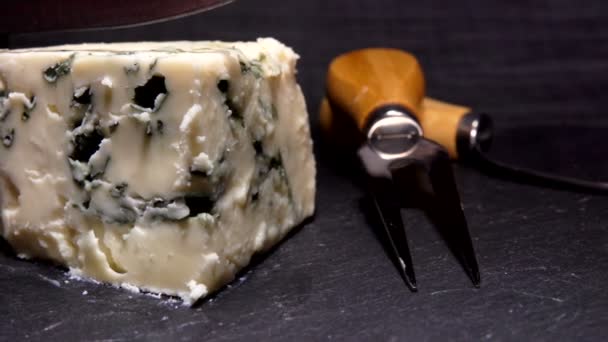 Нож режет и поднимает кусок сыра синей плесени — стоковое видео