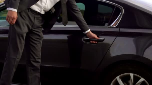 Chauffeur opent de auto deur voor zijn cliënt — Stockvideo